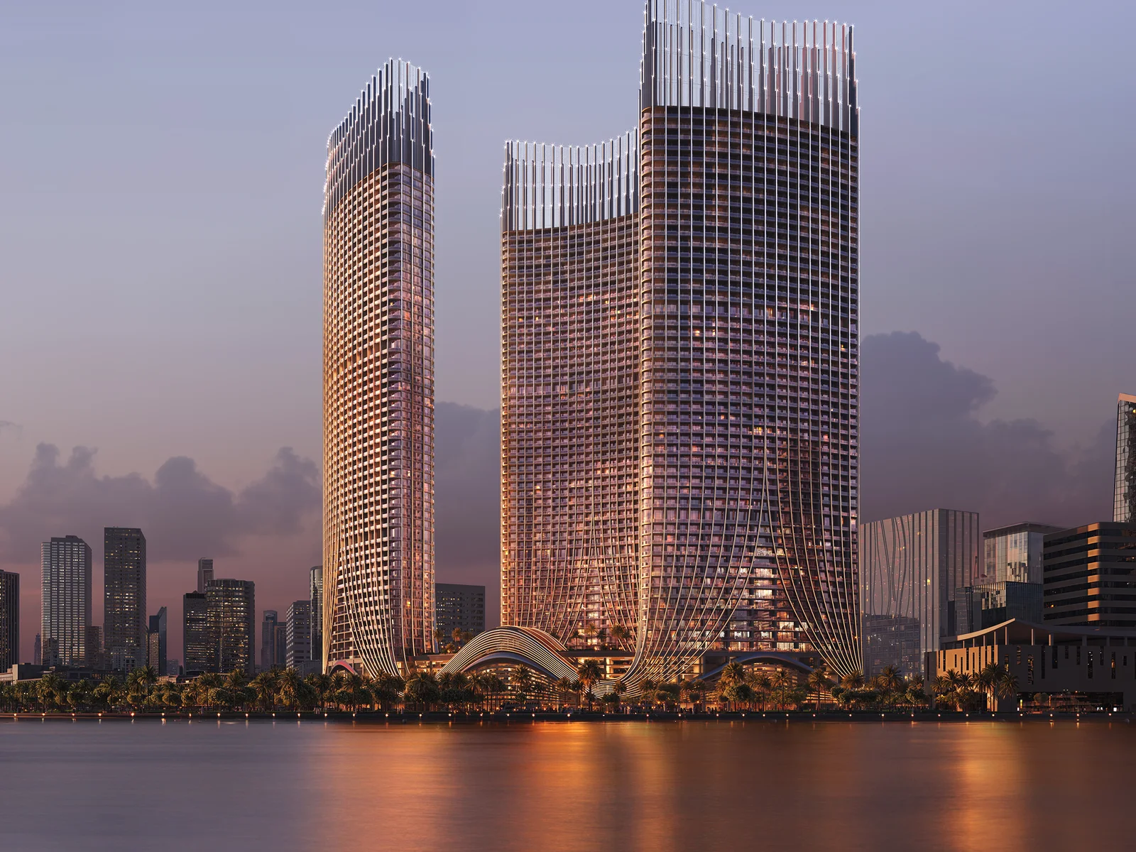 Binghatti Skyrise, drei T&uuml;rme am Wasser im Sonnenuntergang mit Reflexion
